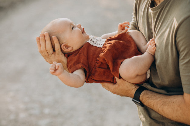 Father holding a girl baby on hands